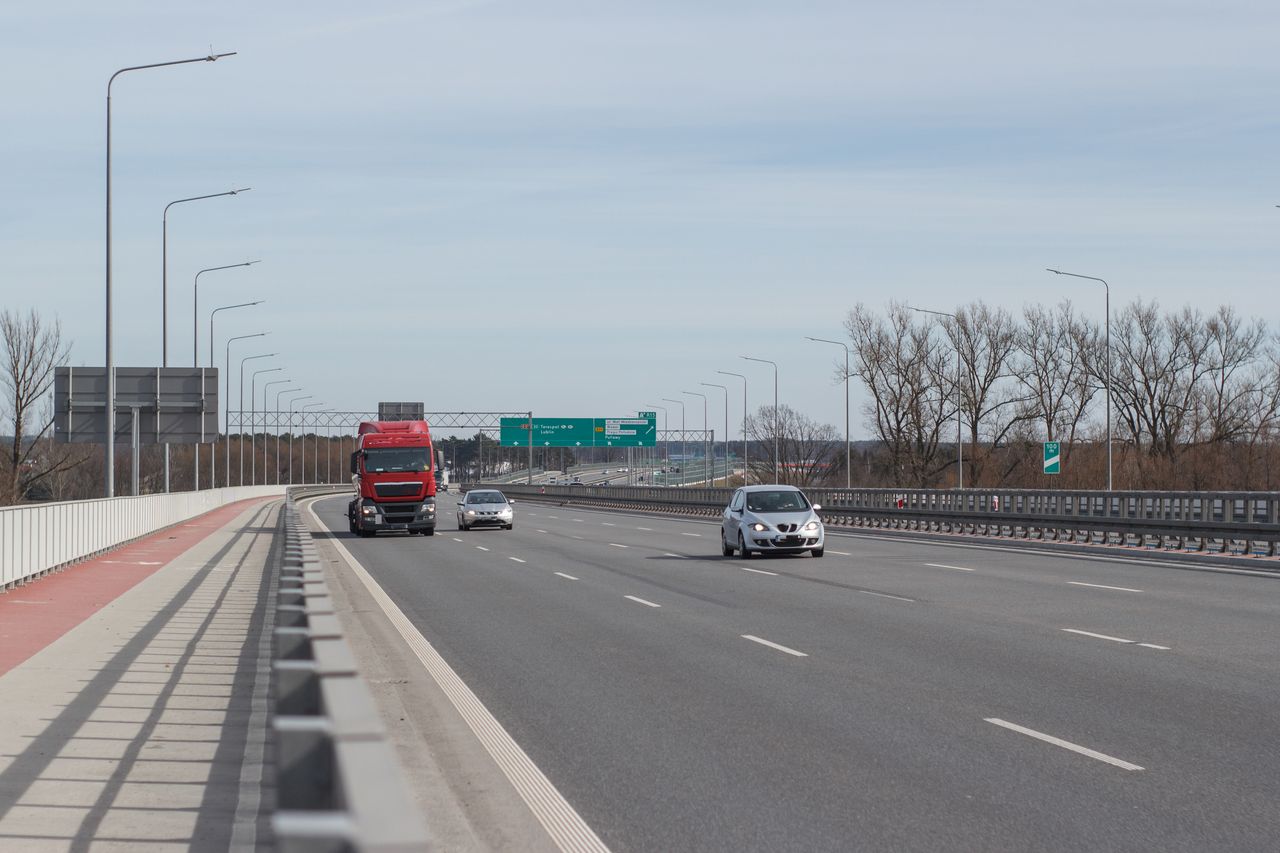 Wide view of a highway in Warsaw with vehicles under a clear sky.